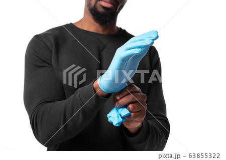 How coronavirus changed our lives. Young man wearing protective gloves on white background 63855322