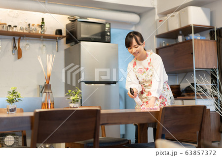 リビングでテーブルを拭く若い女性 リビングでテーブルを拭く若い女性 63857372