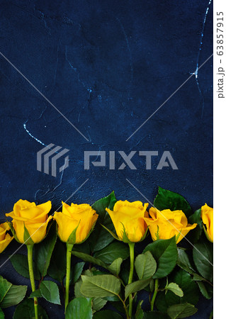 Vertical shot from above of yellow roses on dark 63857915