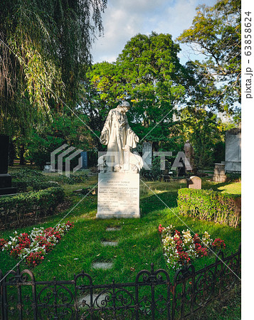 Old grave with a monument to a famous person in the cemetery. Architectural stone statue,old historic grave and funeral monument in Budapest, Hungary. Old grave with a monument to a famous person in the cemetery. Architectural stone statue,old historic grave and funeral monument in Budapest, Hungary. 63858624
