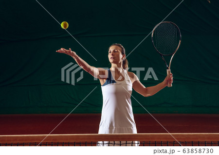 Young caucasian professional sportswoman playing tennis on sport court background Young caucasian professional sportswoman playing tennis on sport court background 63858730