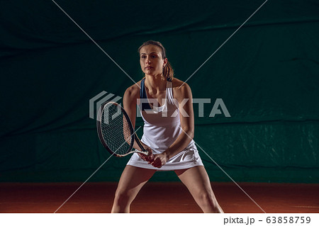 Young caucasian professional sportswoman playing tennis on sport court background 63858759