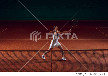 Young caucasian professional sportswoman playing tennis on sport court background Young caucasian professional sportswoman playing tennis on sport court background 63858771