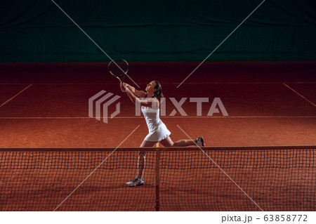 Young caucasian professional sportswoman playing tennis on sport court background 63858772