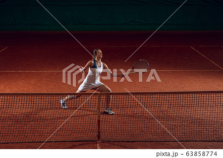 Young caucasian professional sportswoman playing tennis on sport court background Young caucasian professional sportswoman playing tennis on sport court background 63858774