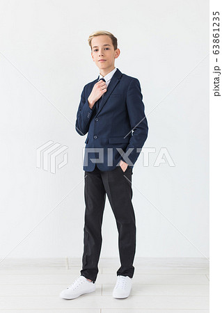 Portrait of stylish school boy teenager in white shirt and jacket against white background. Portrait of stylish school boy teenager in white shirt and jacket against white background. 63861235