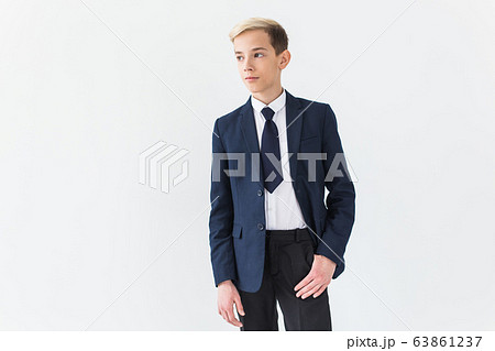 Portrait of stylish school boy teenager in white shirt and jacket against white background with copy space. Portrait of stylish school boy teenager in white shirt and jacket against white background with copy space. 63861237