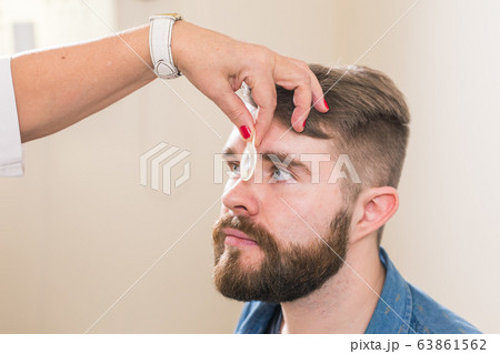 Medicine, health, ophthalmology concept - Ophthalmologist examines patient's eyes. 63861562