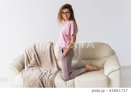 Young attractive woman dressed in beautiful colorful pajama posing as a model in her living room. Comfortable sleepwear, home relaxation and female fashion concept. Young attractive woman dressed in beautiful colorful pajama posing as a model in her living room. Comfortable sleepwear, home relaxation and female fashion concept. 63861737