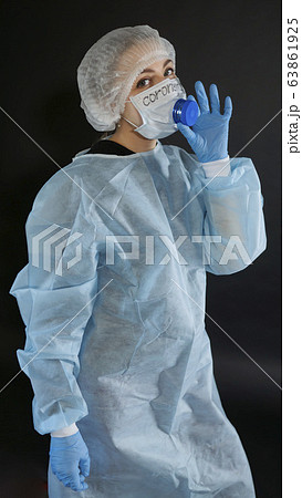 Young woman in protective clothing. On the face of a protective medical mask with a valve for eating. 63861925