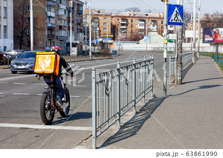 A young man with an orange backpack on his back A young man with an orange backpack on his back 63861990