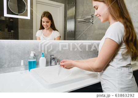 Smiling girl lather wash hands with soap Smiling girl lather wash hands with soap 63863292