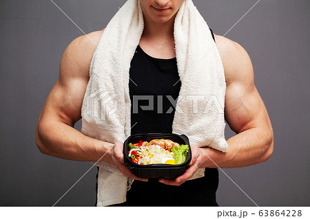 Closeup of a man holding a box full of protein rich foods for sports nutrition 63864228