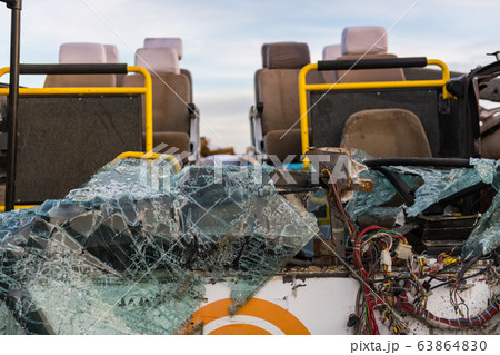 Detail of a crashed bus with no roof and broken front glass. 63864830