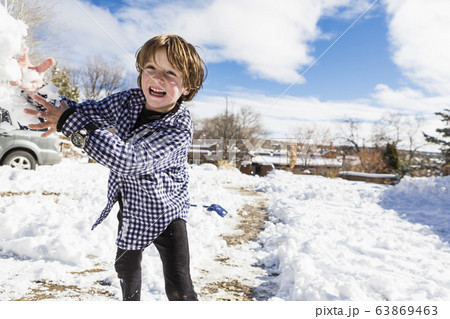 A young boy throwing a snowball A young boy throwing a snowball 63869463