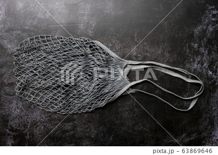 High angle close up of empty grey net bag on black background. 63869646