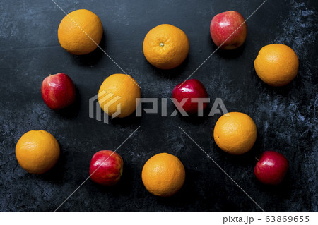 High angle close up of red apples and oranges on black background. 63869655