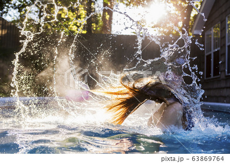 A teenage girl swimming in a pool A teenage girl swimming in a pool 63869764