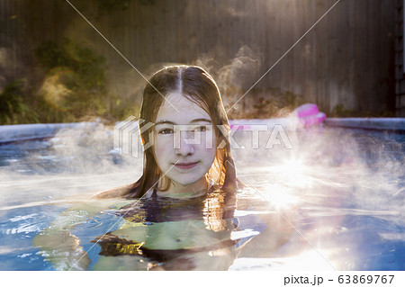 A teenage girl swimming in a pool 63869767