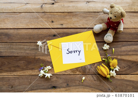 sorry message card handwriting in yellow envelope with white flowers jasmine, yellow flower ylang ylang and teddy bear 63870101