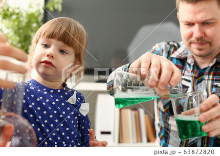 Man and little girl play with colourful liquids Man and little girl play with colourful liquids 63872820