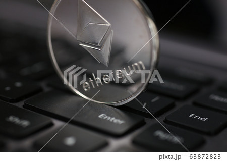 Silver ethereum coin is lying on laptop 63872823