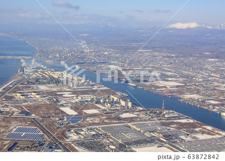 厳冬の北海道、樽前山を背景に道南の港町、苫小牧港と市街地を上空から見る 63872842