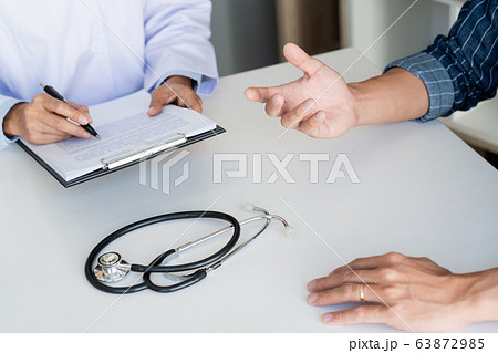doctor working with patient taking notes with 63872985