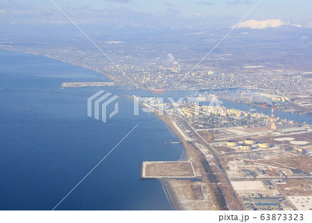 厳冬の北海道、樽前山を背景に道南の港町、苫小牧港と市街地を上空から見る 63873323