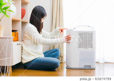 除湿機　操作　女性　コピースペース 63874799