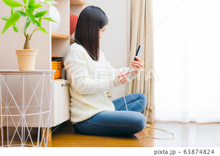 ケーブルを挿す、抜く女性　スマートフォン　コピースペース 63874824