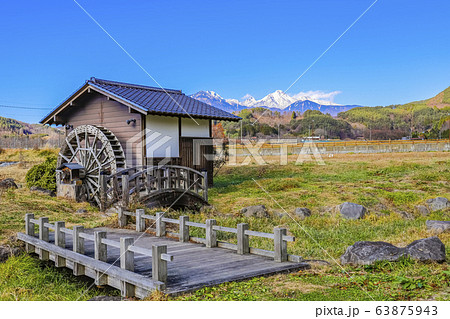 山梨県北杜市 山梨県指定文化財 津金学校に隣接の冬の水車小屋と八ヶ岳の写真素材