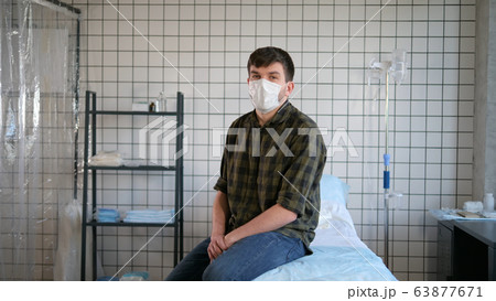 Isolated man sitting on a bed in hospita and talking to camera. Isolated man sitting on a bed in hospita and talking to camera. 63877671