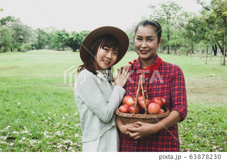 Beautiful family woman smile holding and eating apples at park. 63878230