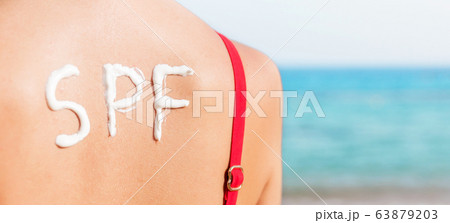 SPF word made of sunblock at woman's back at the 63879203