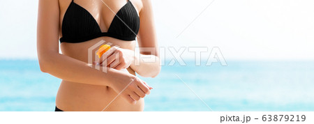 Young woman is applying protective sun cream on 63879219