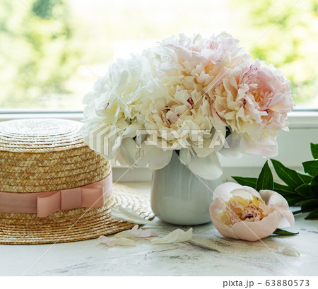 Straw hat and peonies 63880573