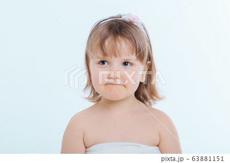 a little girl grimaces against a white background. The child is up to something. Concept of emotions , facial expressions, childhood, sincerity a little girl grimaces against a white background. The child is up to something. Concept of emotions , facial expressions, childhood, sincerity 63881151