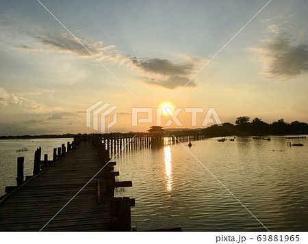 The U Bein Bridge is old longest wooden bridge in Mandalay city, Myanmar on sunset scene twilight sky background 63881965
