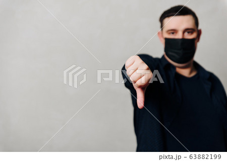 a man in a black medical mask on a gray background 63882199