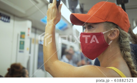 Woman travel caucasian ride at overground train airtrain with wearing protective medical mask. Girl tourist at airtrain with respirator. People mask. 63882525