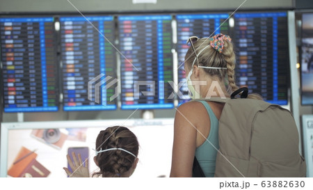 Woman and child baby tourist caucasian at airport with wearing protective medical mask. Family in quarantine isolation. Coronavirus covid-19. Woman and child baby tourist caucasian at airport with wearing protective medical mask. Family in quarantine isolation. Coronavirus covid-19. 63882630