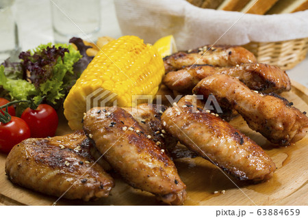 Grilled chicken wings with sweet corn. Close-up shot. 63884659