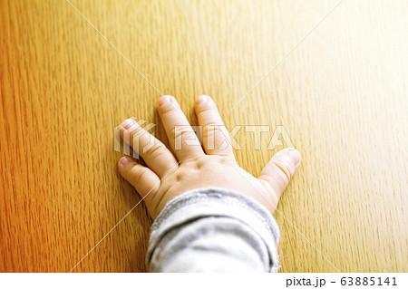 赤ちゃんの愛らしいぷっくりした手とコピースペースと木目バック 赤ちゃんの愛らしいぷっくりした手とコピースペースと木目バック 63885141