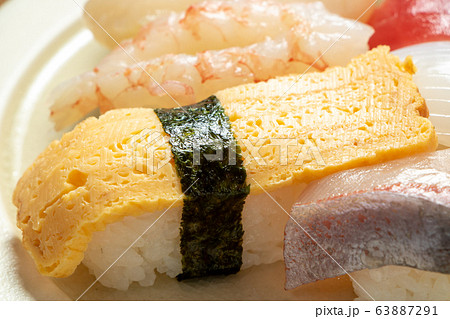 にぎり寿司盛り合わせの、玉子寿司を中心としたアップ。 にぎり寿司盛り合わせの、玉子寿司を中心としたアップ。 63887291