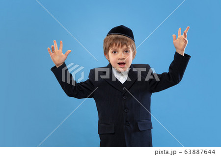 Portrait of a young orthodox jewish boy isolated on blue studio background, meeting the Passover 63887644