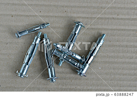 Metal expansion bolt shields or anchor bolts on a gray table. 63888247