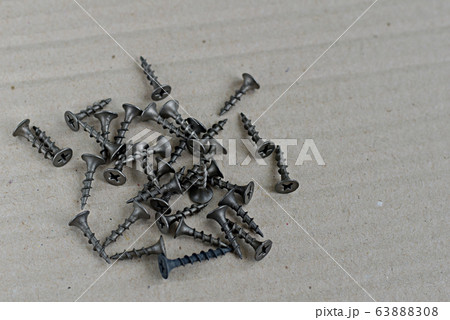 Short screws made of dark metal for attaching drywall. 63888308