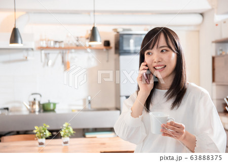 朝、自宅でコーヒーを飲む若い女性 63888375