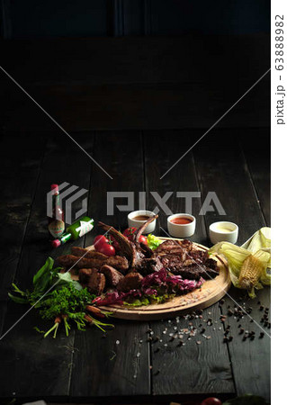 Meat on the bone on a wooden board . catering menu Meat on the bone on a wooden board . catering menu 63888982